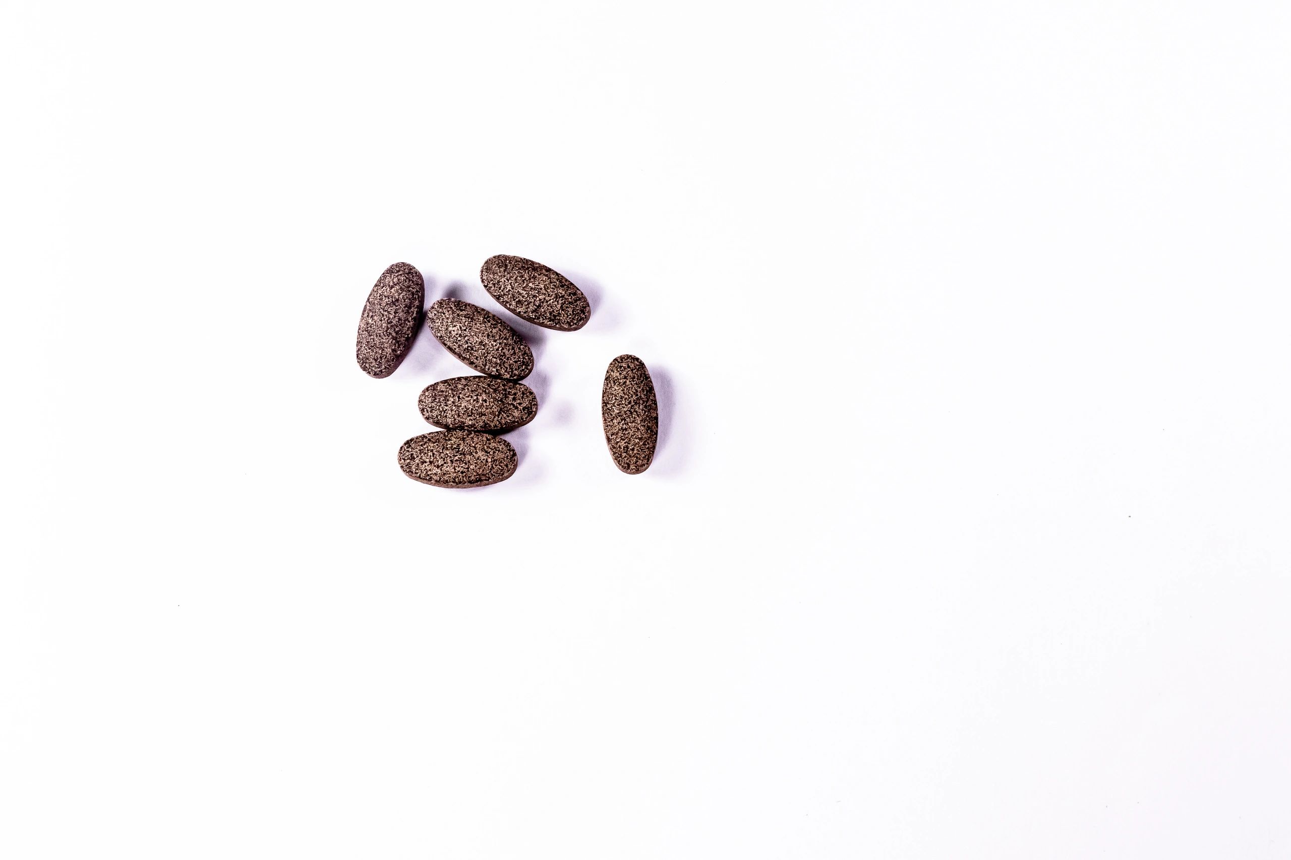 Herbal supplement capsules arranged on a white background