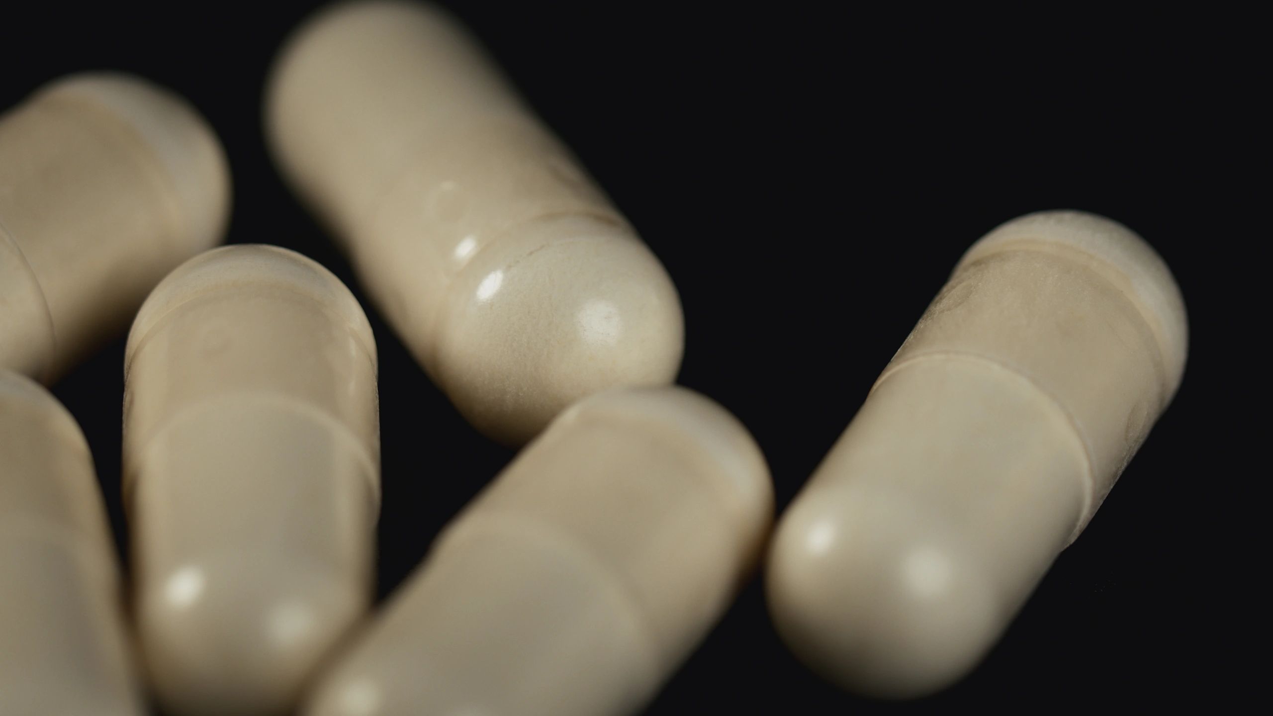 Supplement capsules on a dark background